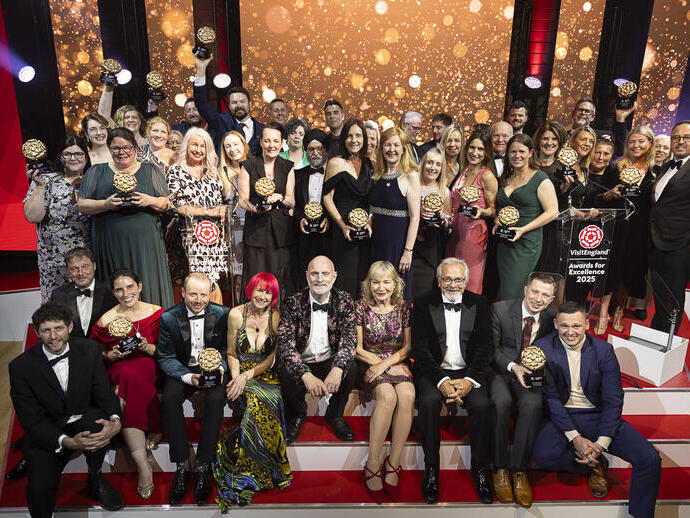 Un gruppo di vincitori sul palco con i loro premi durante una cerimonia di gala.