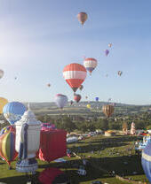 Globos aerostáticos de colores flotando sobre el campo