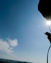 Climber rappelling from a cliff shot from below