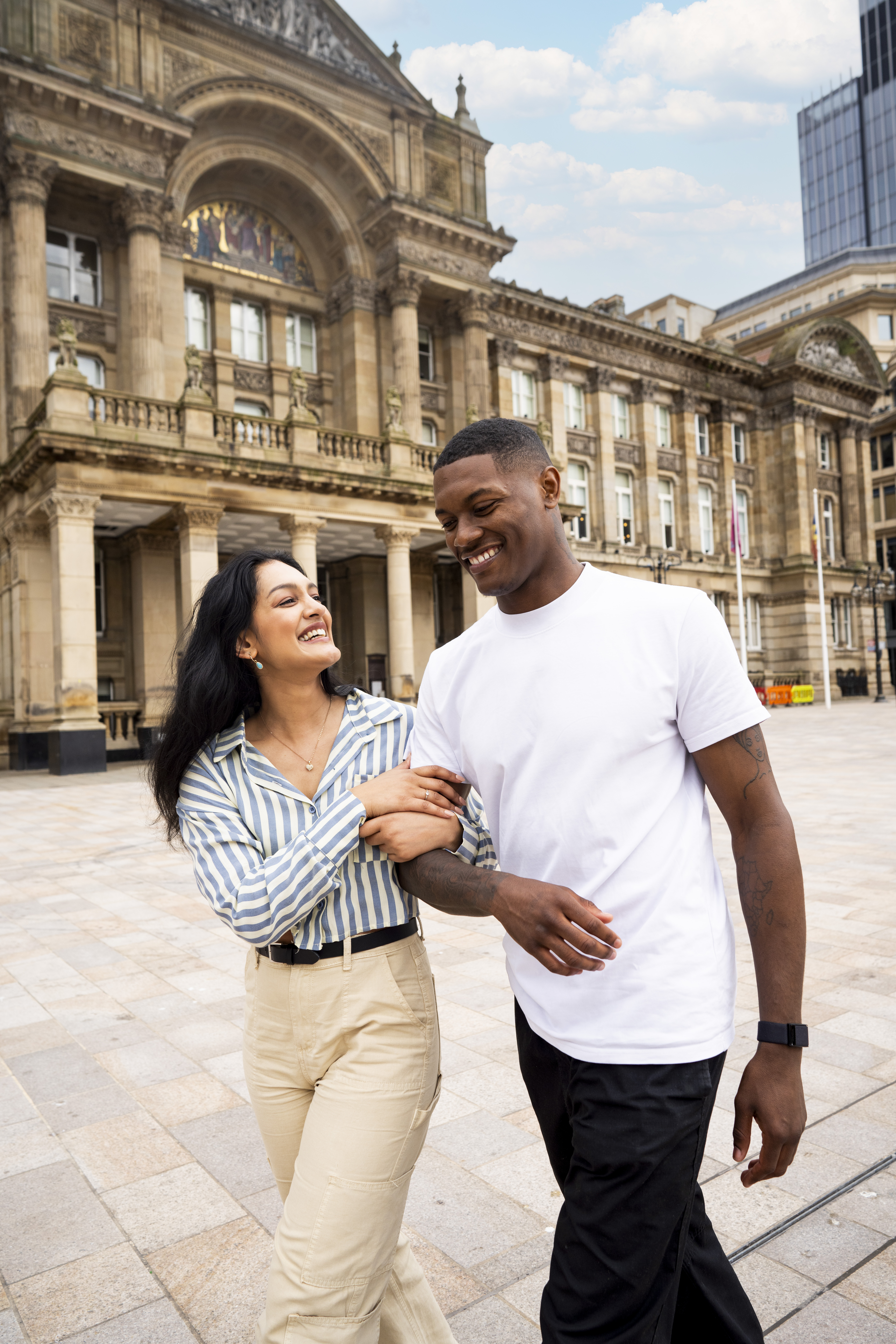 Une femme et un homme se promènent sur une place de ville