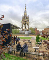 Des gens assis dans un jardin extérieur avec vue sur un grand mémorial.