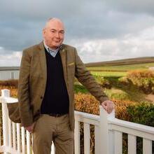 Man standing outdoor, an open field in the background