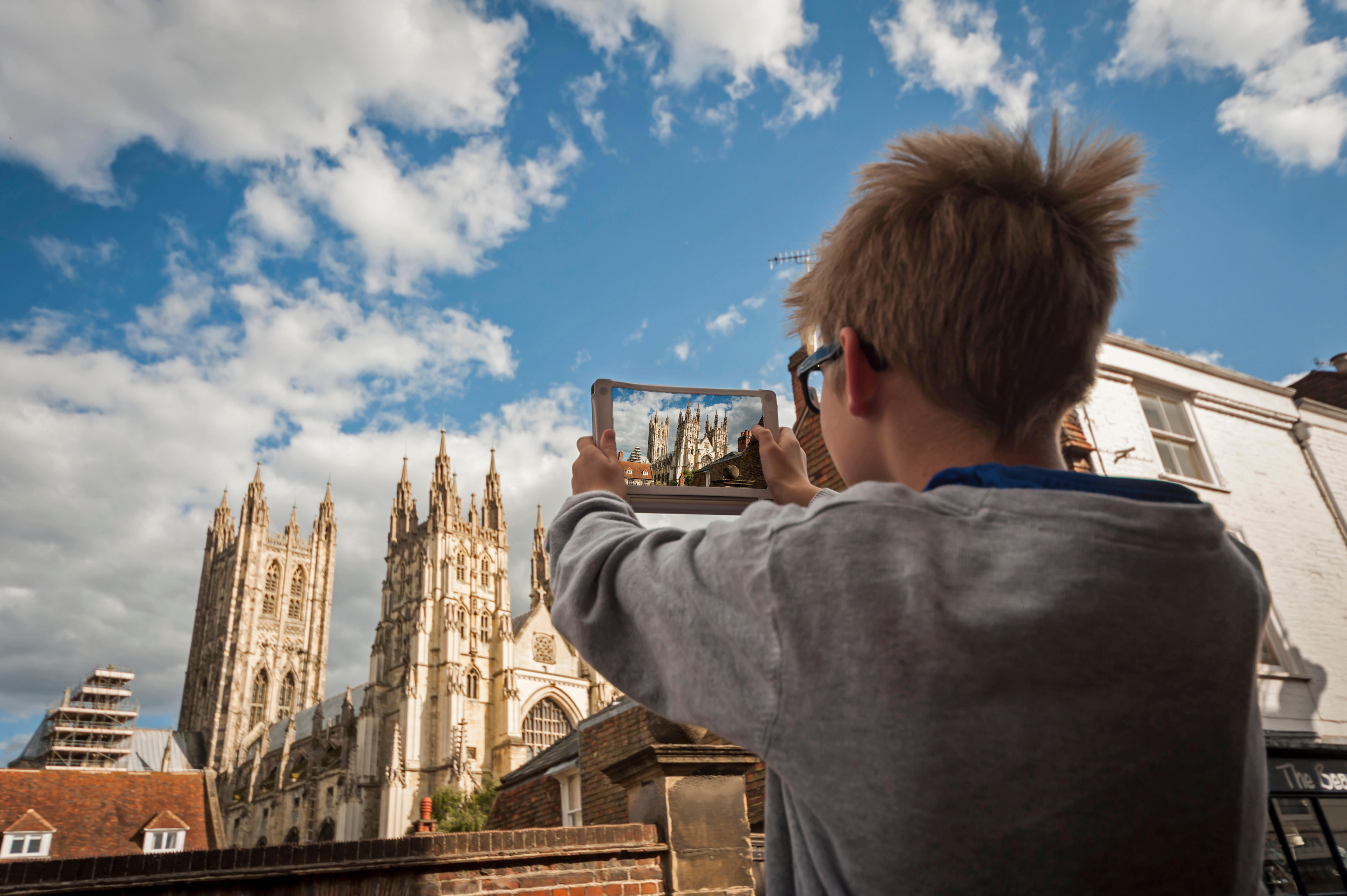 Boy photographing Canterbury Cathedral with his digital tablet