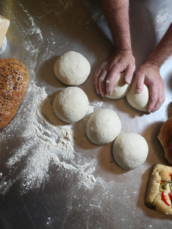Fresh baked goods being prepared by a baker.