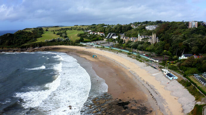 Luftaufnahme eines Strandes mit kleinen Strandhütten.