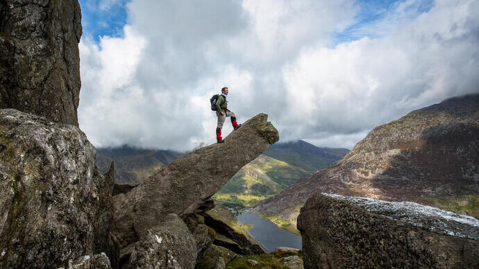 Un homme debout sur un rocher en saillie, admirant la vue