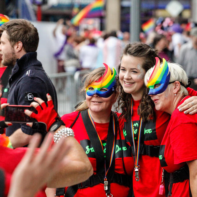 Mujeres con máscaras arcoíris celebrando el festival del Orgullo.
