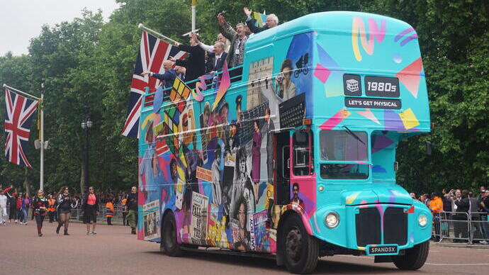 Bild eines blauen Reisebusses mit Union-Jack-Flaggen