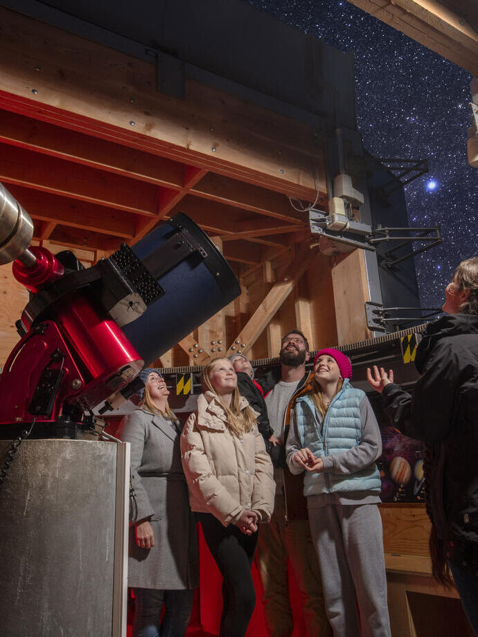 A family stand with a tour guide at an Observatory