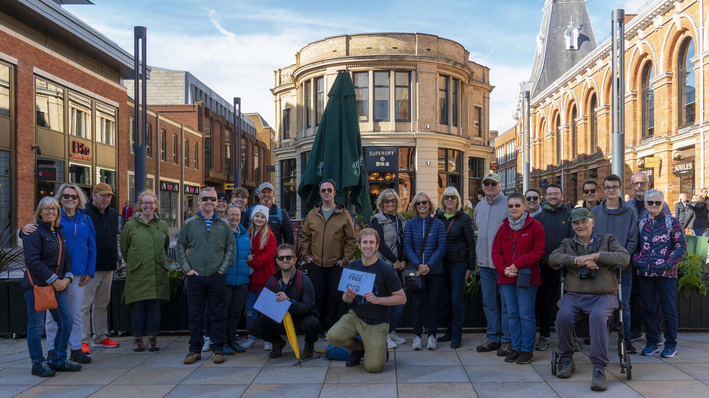 A walking tour group posing in Lincoln's city centre