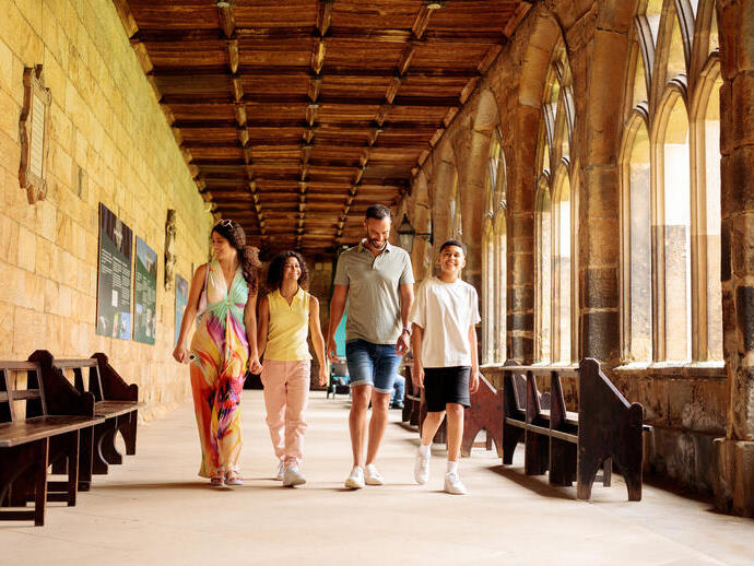 Family walking through the cloisters of a cathedral
