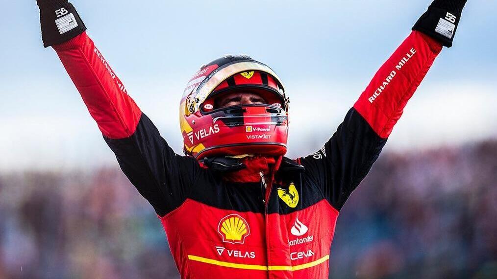 Car racer lifting his arms up in the air