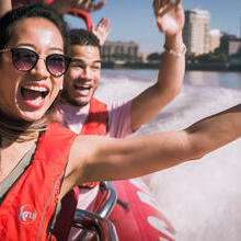 Close up of man young woman and man riding on speed boat on the Thames