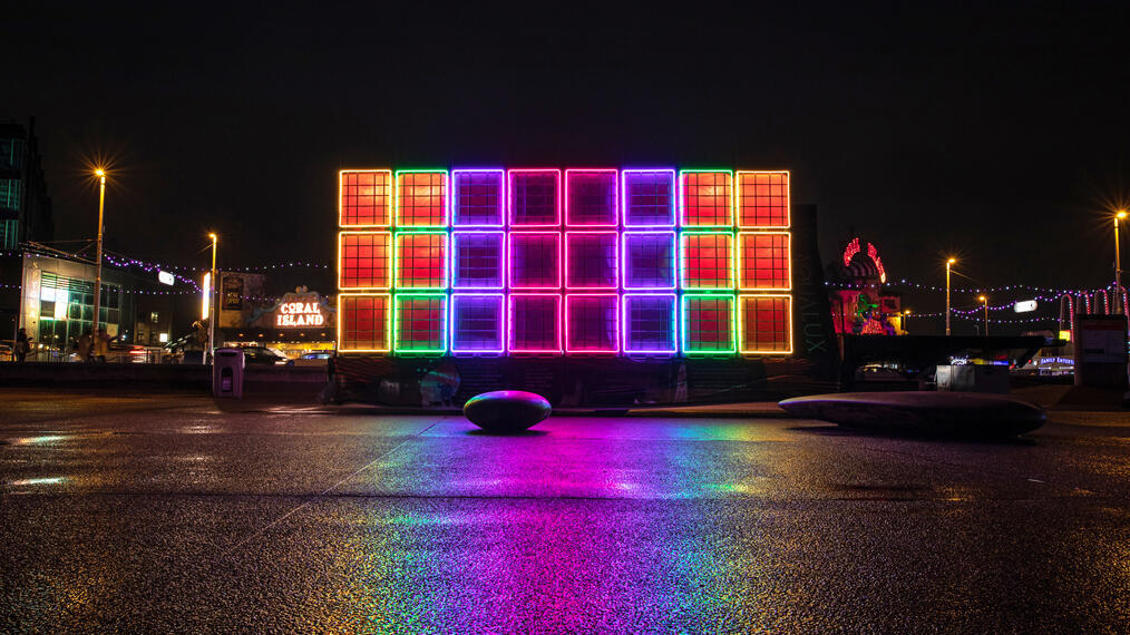 Installation lumineuse colorée la nuit.