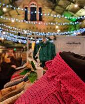 Close up of clothing on market stall at Victoria Baths with coloured lights in the background