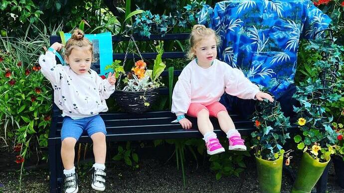 Dos niños sentados en un banco en la exposición floral de Chorley