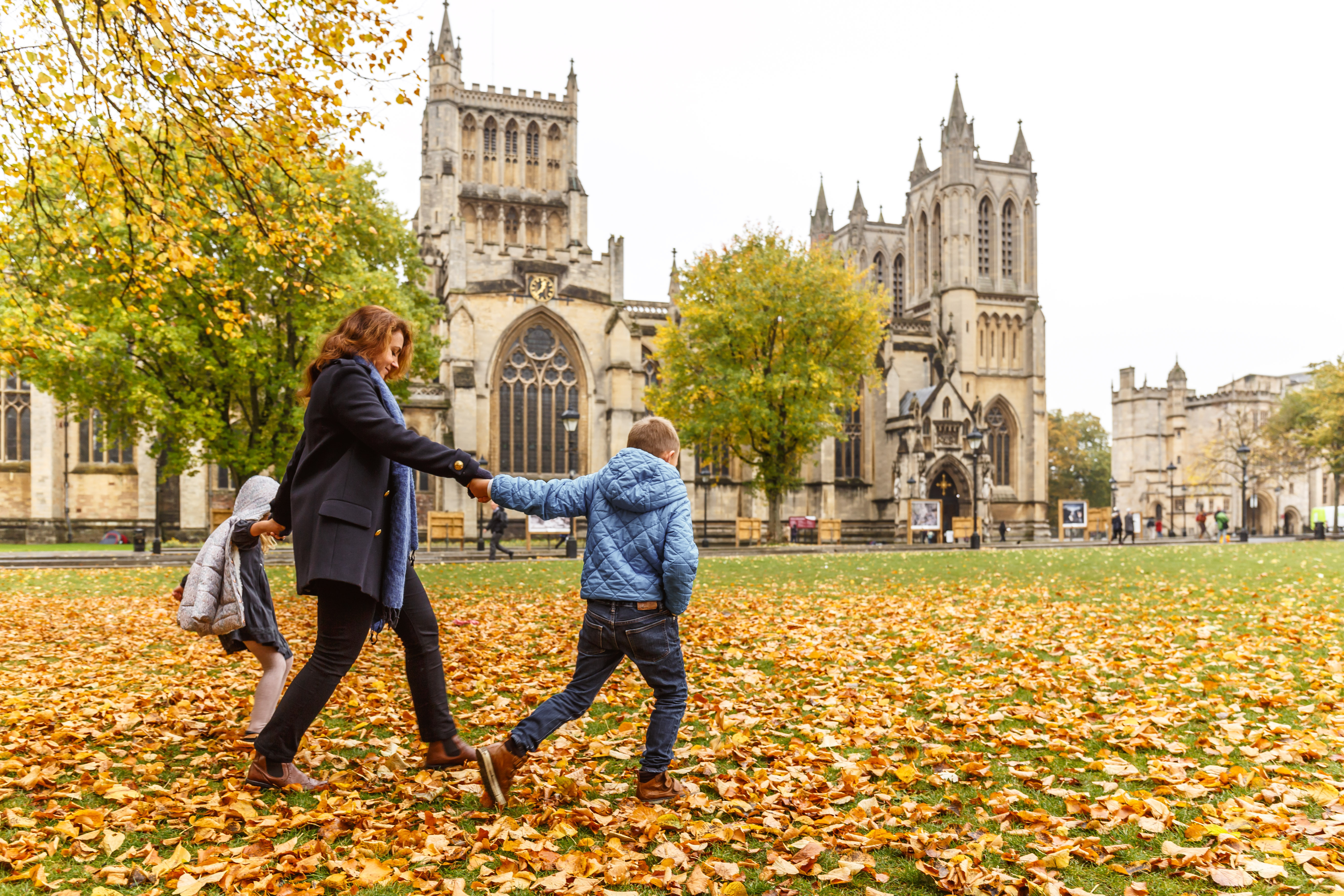 A woman and child walking outside Bristol Cathedral