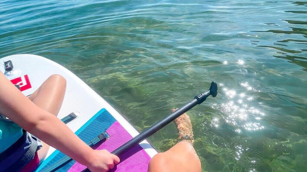 أشخاص جالسون على لوح تزلج في البحر