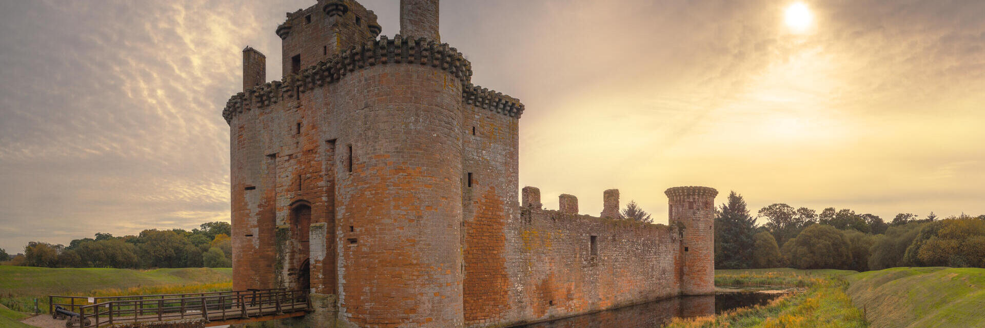 Historisches Schloss und Wassergraben bei Sonnenuntergang