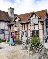 رجل وامرأة يمشيان خارج منزل على طراز تيودور