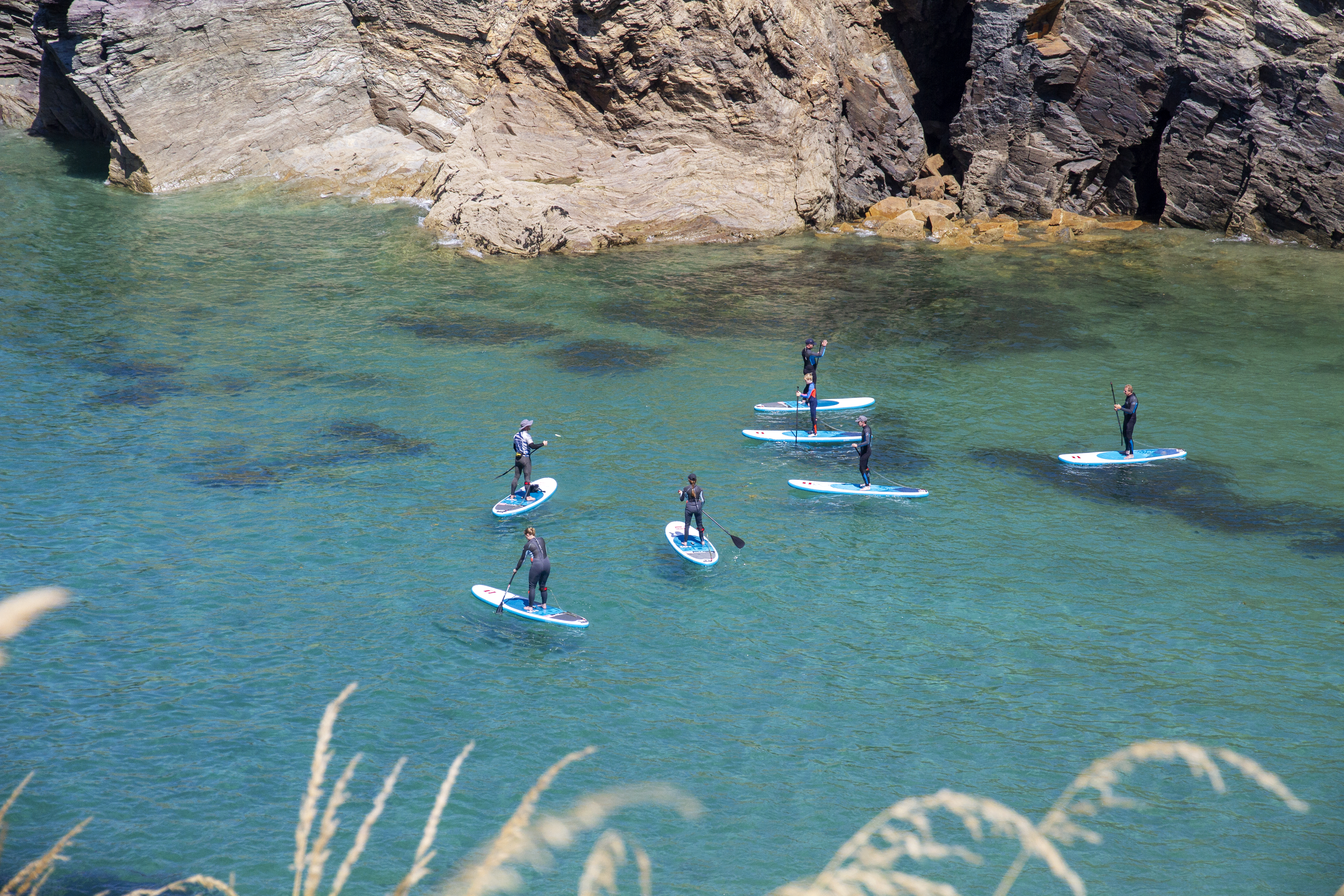 A group of people paddleboarding off the coast of Cornwall