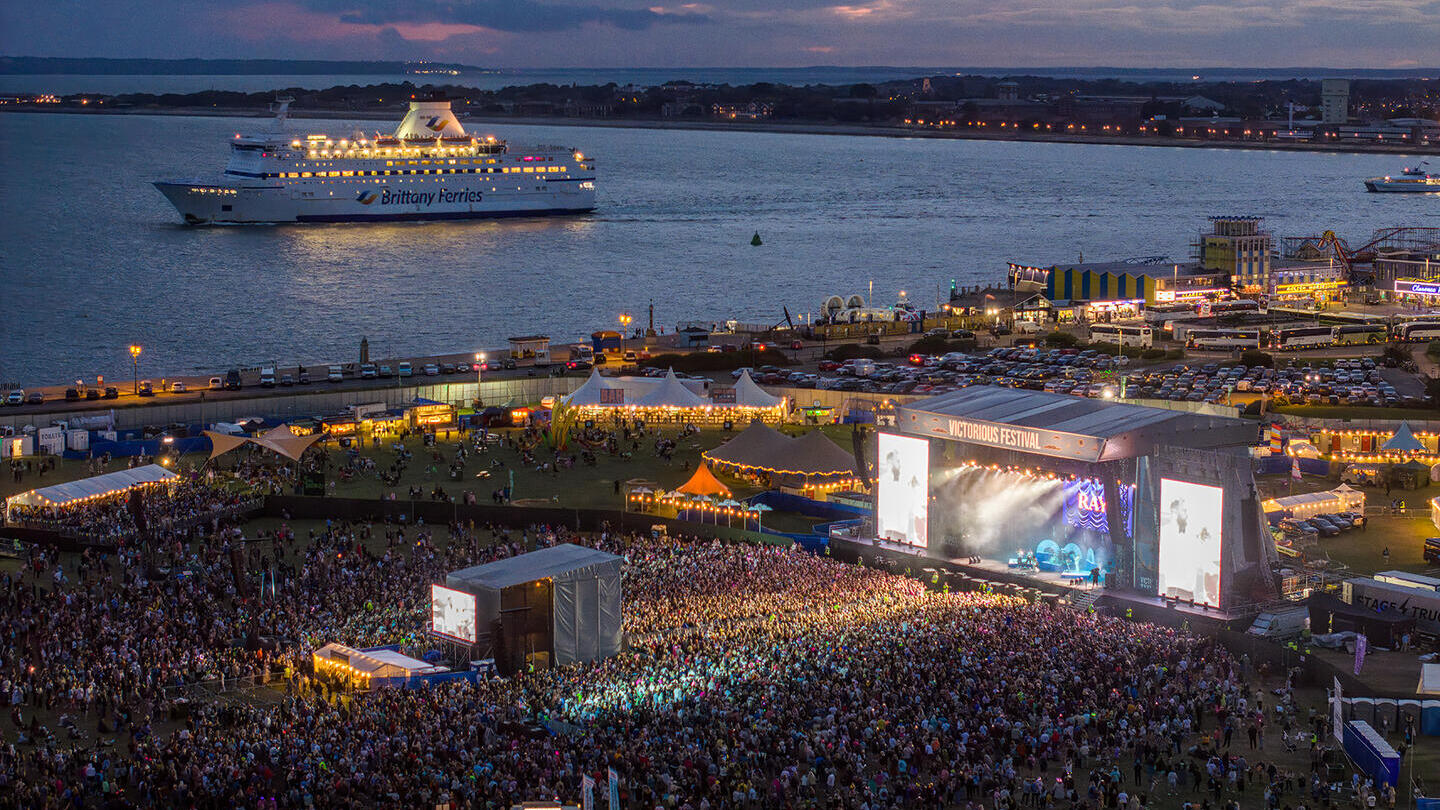 Toma aérea que muestra a la multitud en un festival de música junto al océano