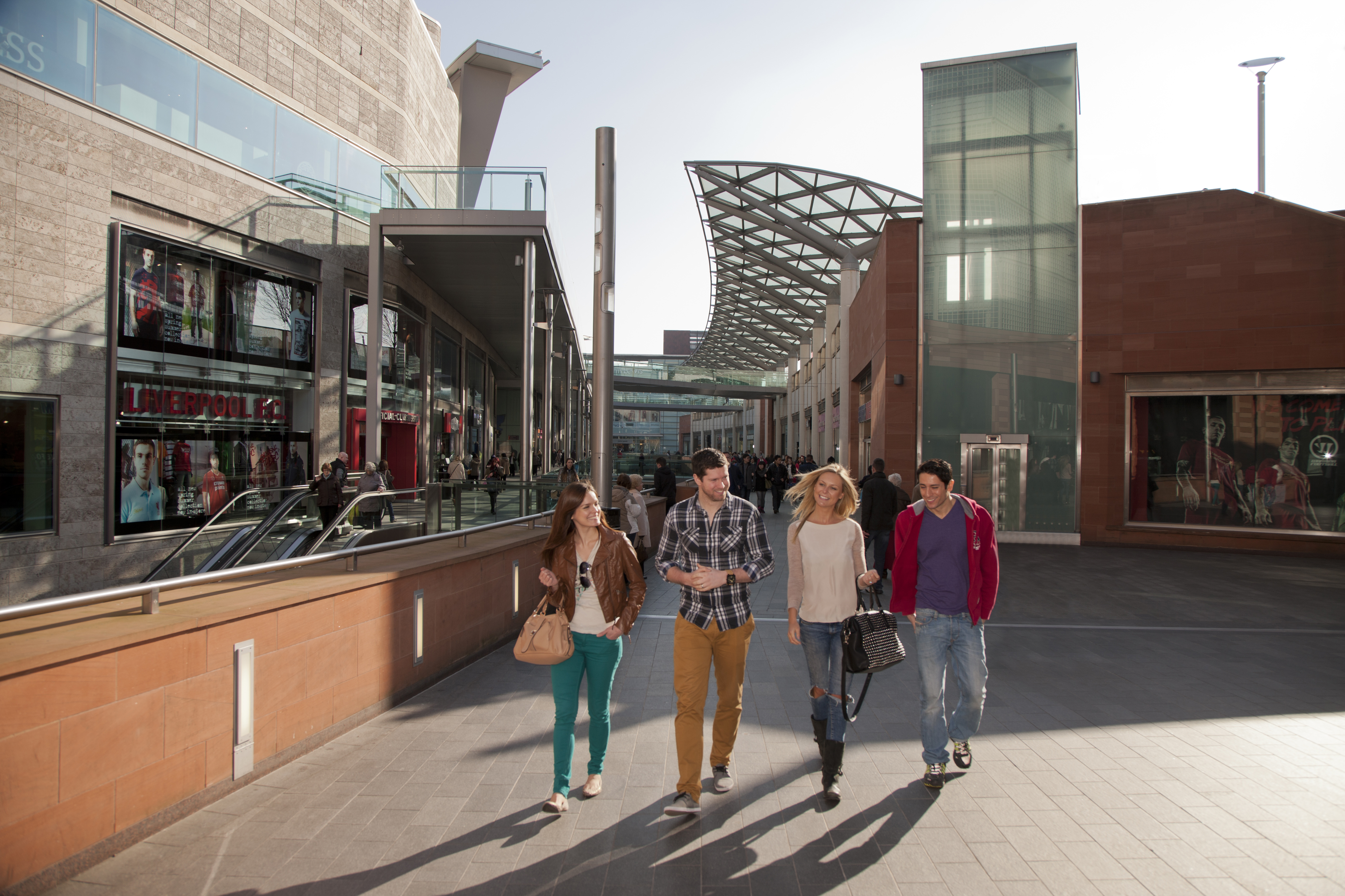 A man and woman, a young couple walking up the ramp outside the new shopping centre development and regeneration in the city.