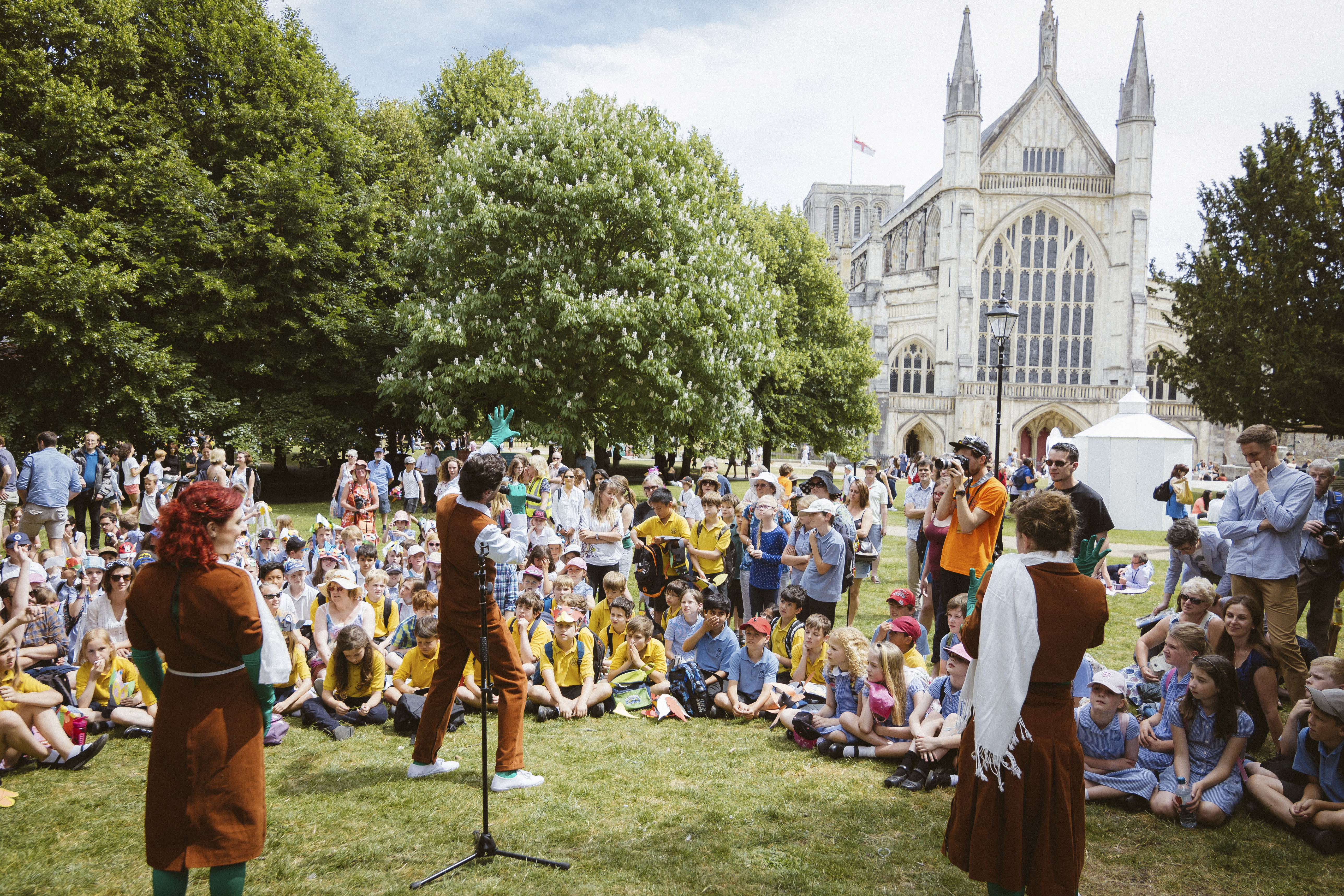 Aufführung vor Publikum auf einer Wiese in der Nähe einer Kathedrale
