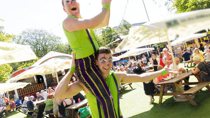 Two acrobats strike a pose at a summer festival
