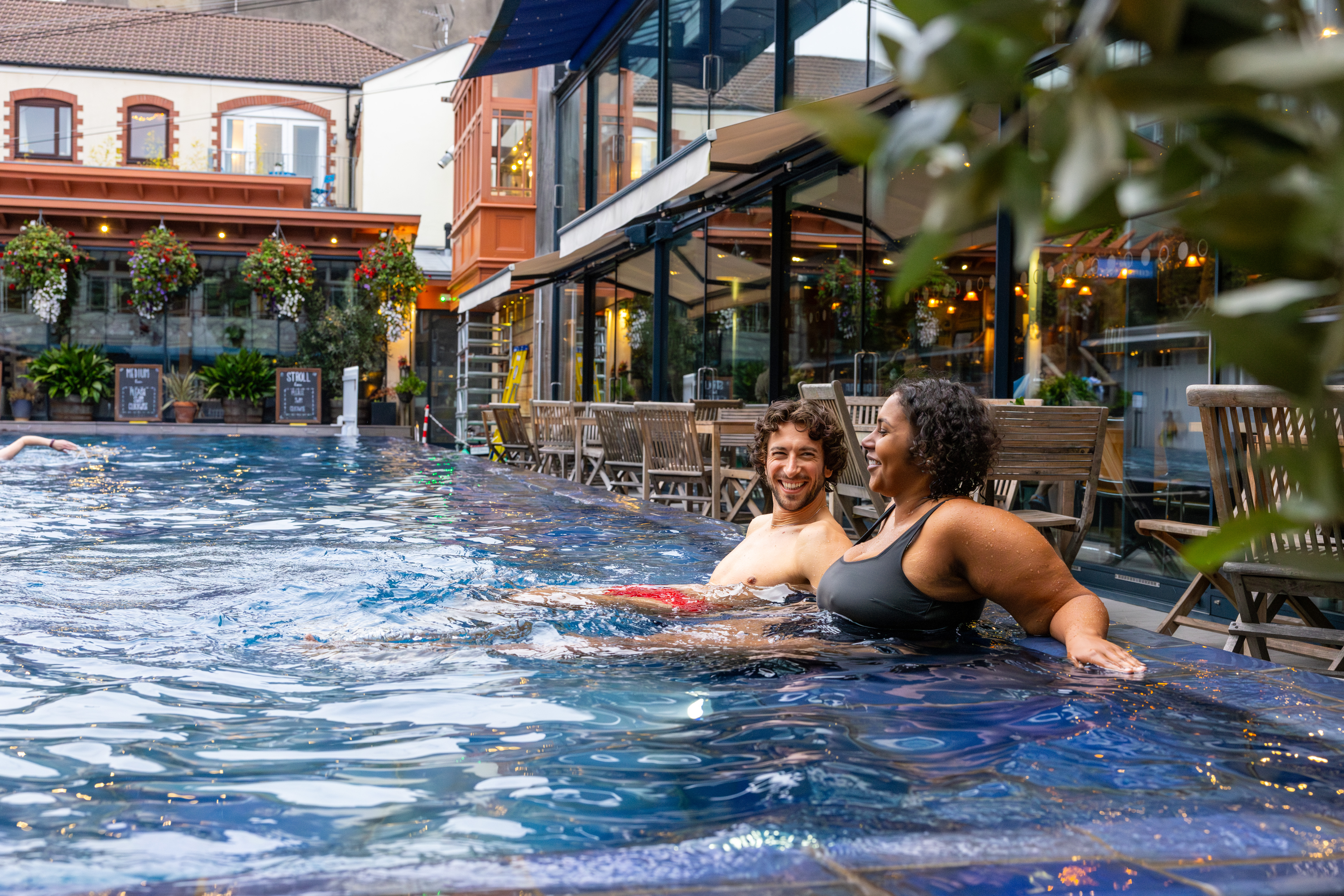 Hombre y mujer relajándose en una piscina al aire libre