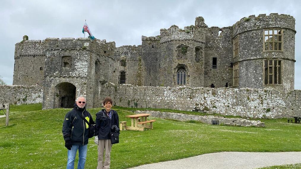 Two people standing outside Pembroke Castle, birthplace of King Henry VII