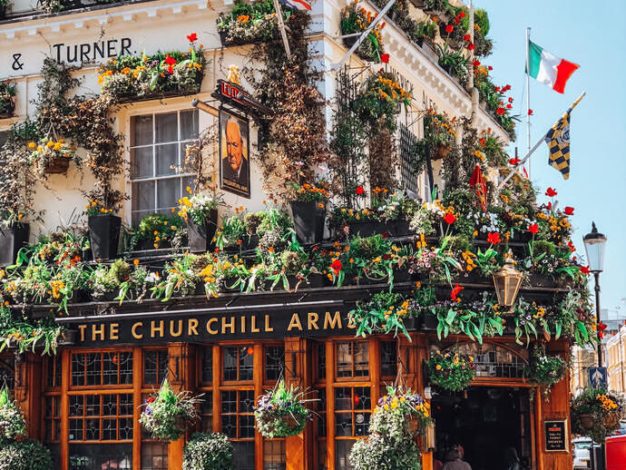 Pub decorato con bandiere e cesti fioriti appesi