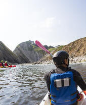 People kayaking along the shores of coastline