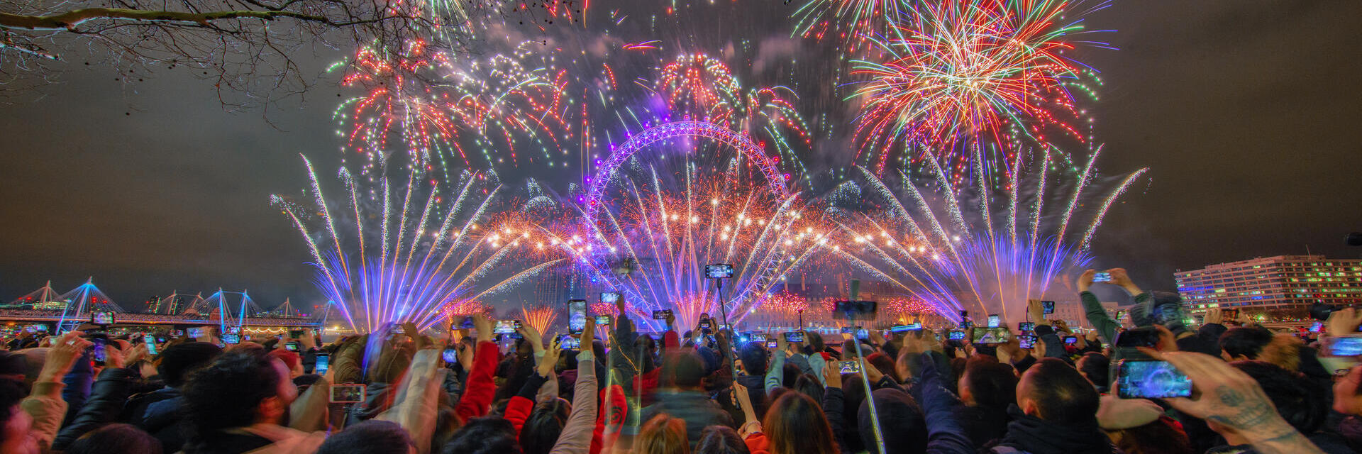 A crowd watching fireworks celebrating New Year's Eve