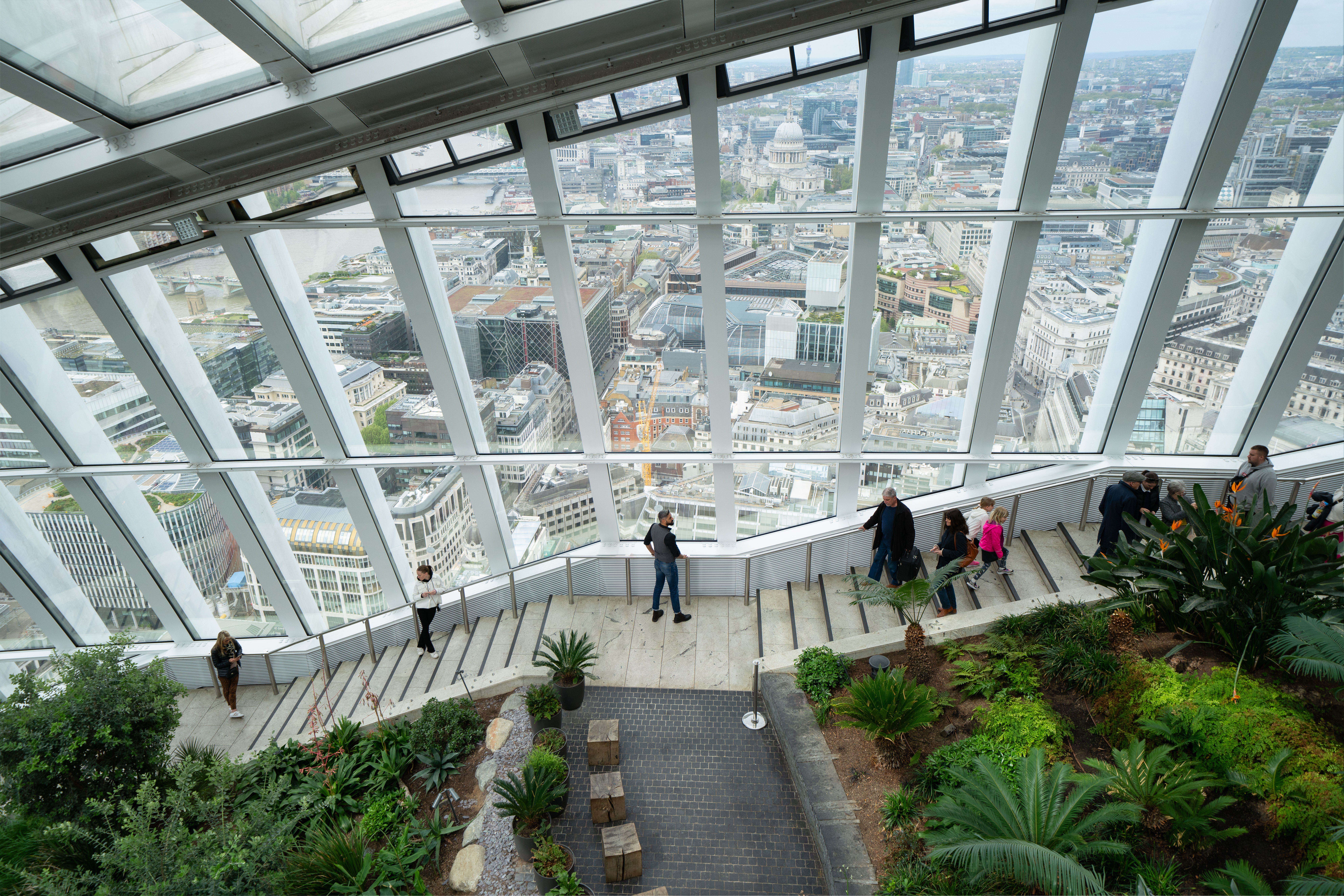 Menschen, die die Treppe zum Sky Garden hinuntergehen, mit der Stadt im Hintergrund