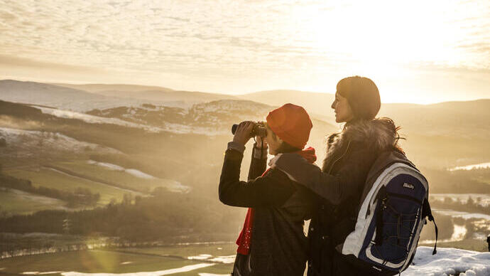 Woman and teenager in a wintery landscape looking at the view