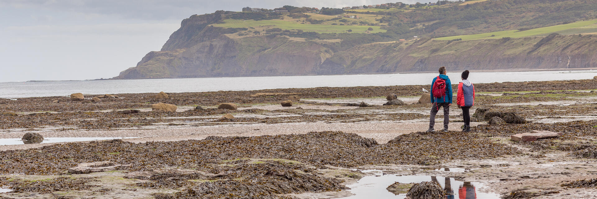 Couple on the beach with cliffs in the background