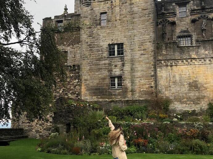 Une femme posant devant le château de Stirling, en Écosse