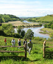 A group of people walking on a hill in the countryside