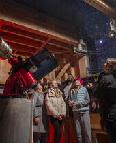 A family stand with a tour guide at an Observatory