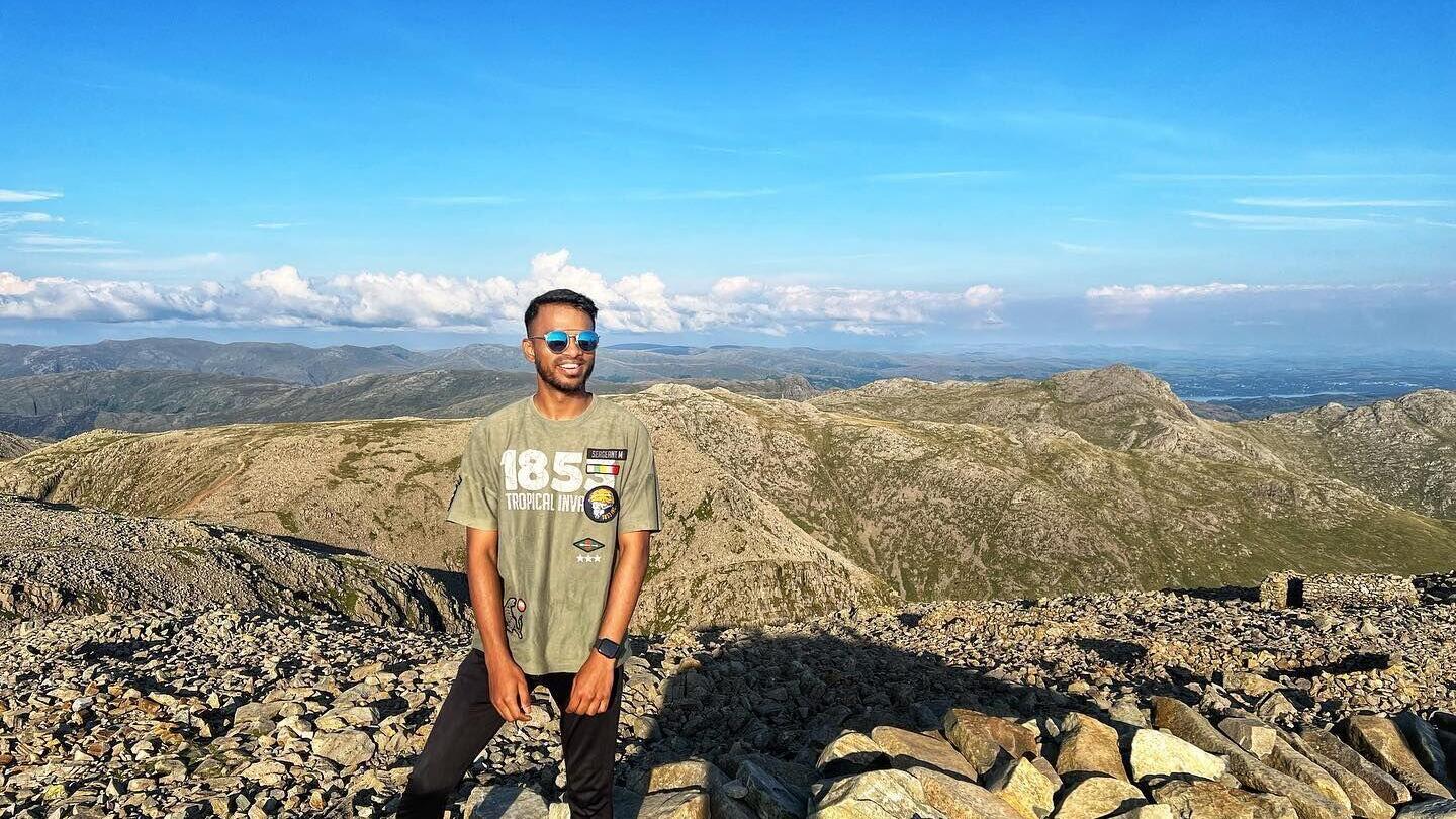 Young man poses on the highest point in England