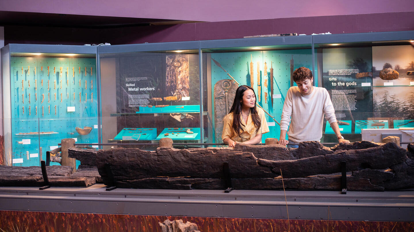 A man and a woman look at an exhibit in a museum