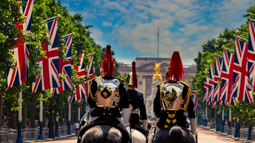 Guardias militares a caballo entre filas de banderas británicas