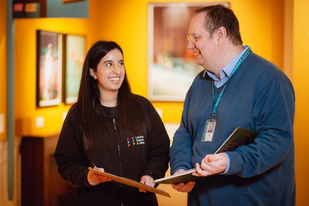Two people talking inside a museum