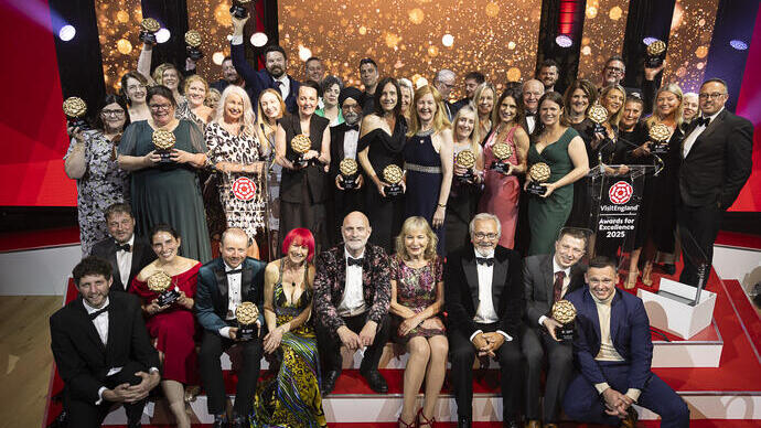 A group of winners on stage holding their awards at a gala ceremony.