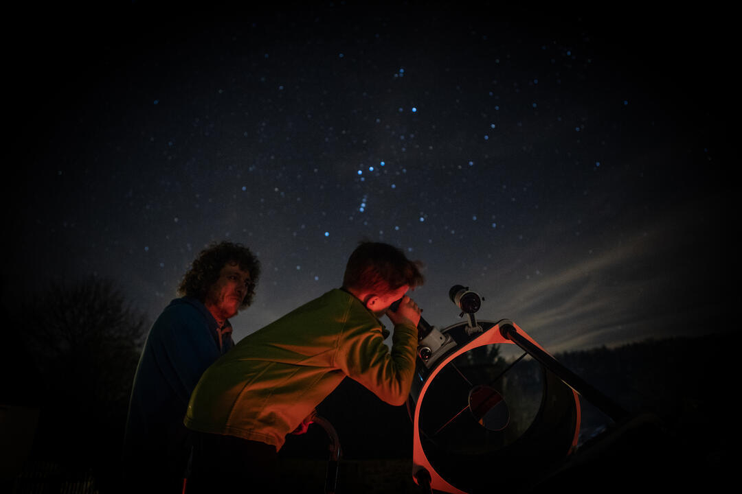 Child stargazing through telescope