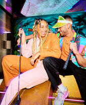 Two people posing with golf clubs at Junkyard Golf in Oxford