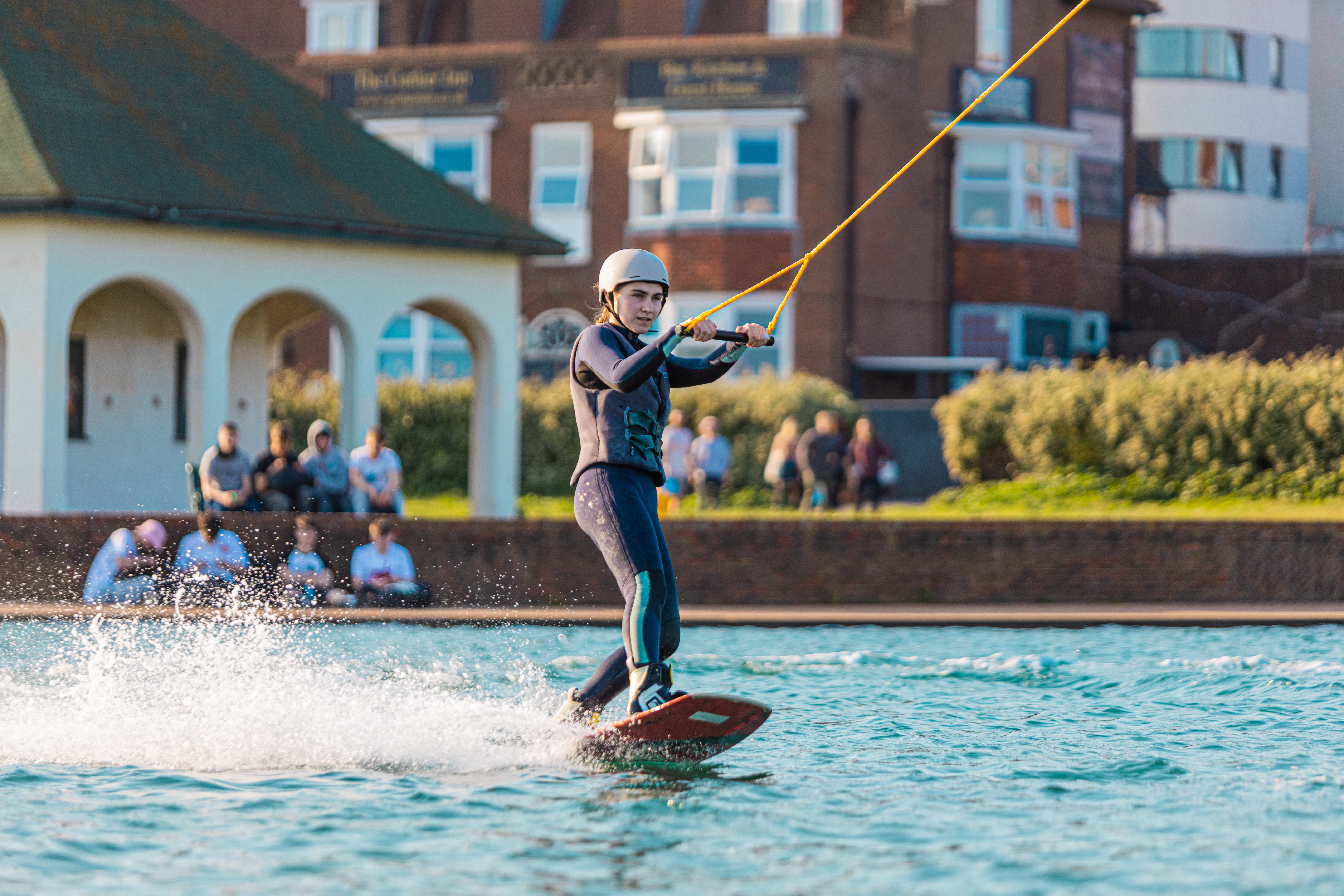 A woman water skiing and holding onto a line at Lagoon Watersports in Brighton