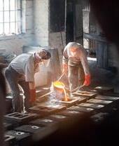 Eine Gruppe von Arbeitern beim Gießen von Stahl in Ironbridge Gorge, einem der Geburtsorte der industriellen Revolution