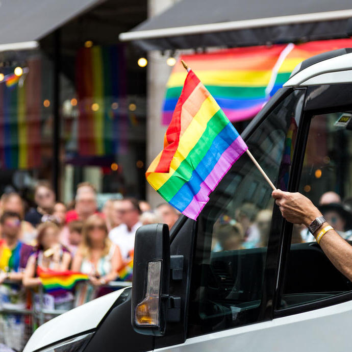 Foule célébrant lors d'une parade de la Pride dans le centre-ville.